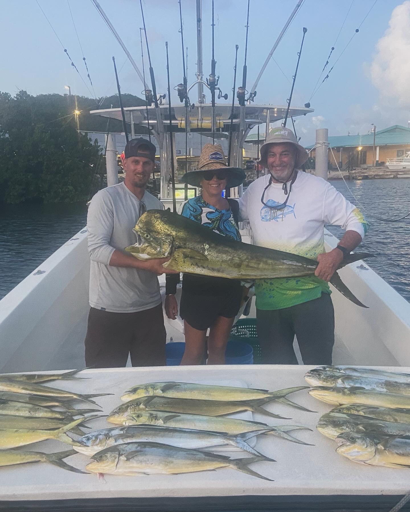 Crew with a big bull mahi and a full spread of dorado at the dock