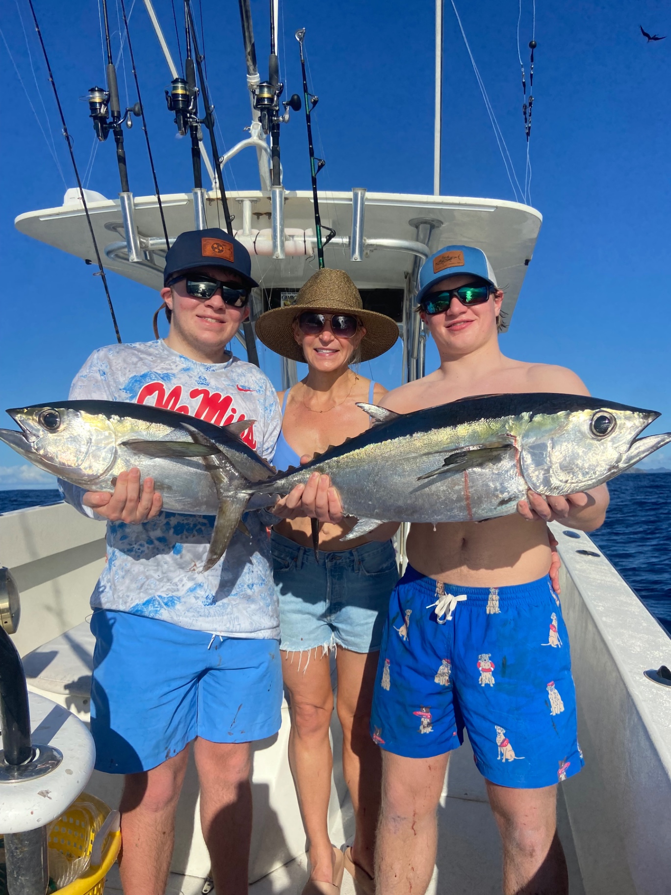 Two anglers and mom holding a pair of blackfin tuna