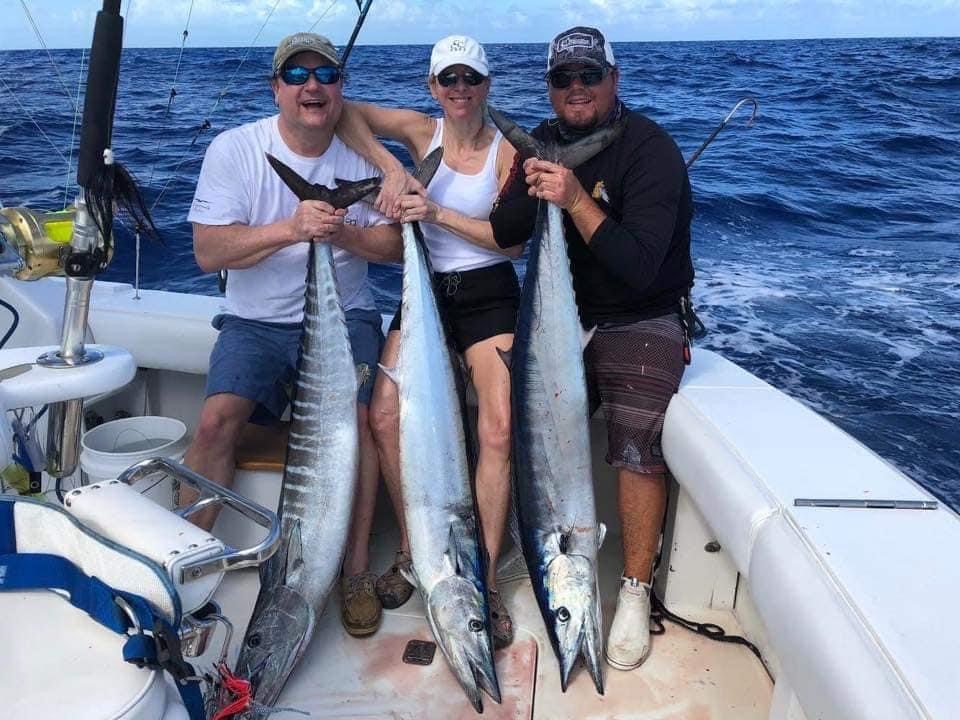 Three anglers holding wahoo aboard Top Shot