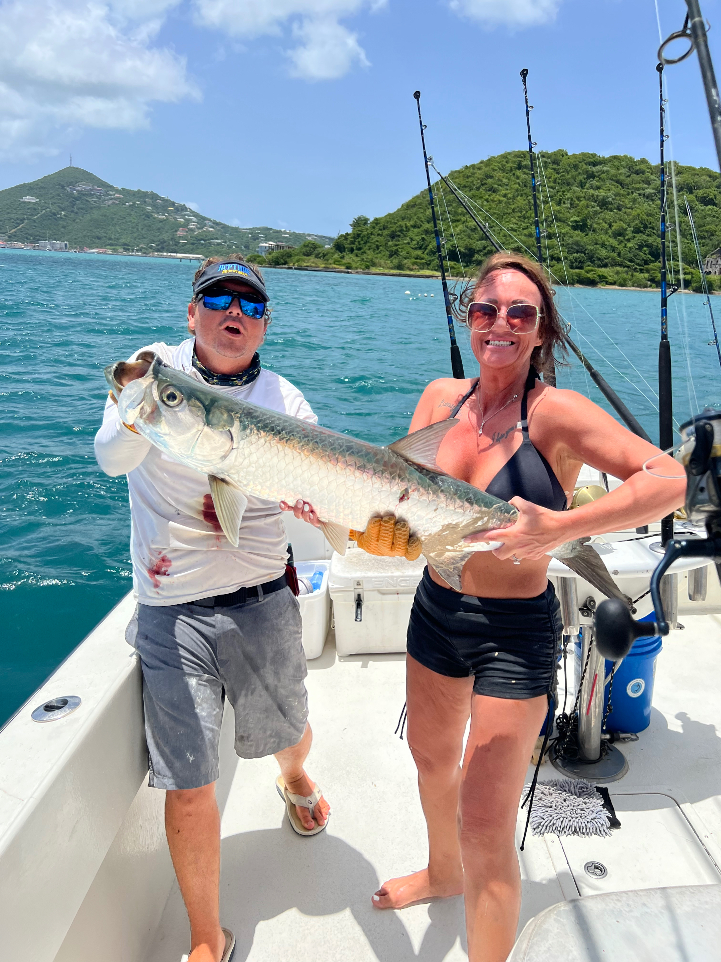 Anglers holding a large tarpon on the deck