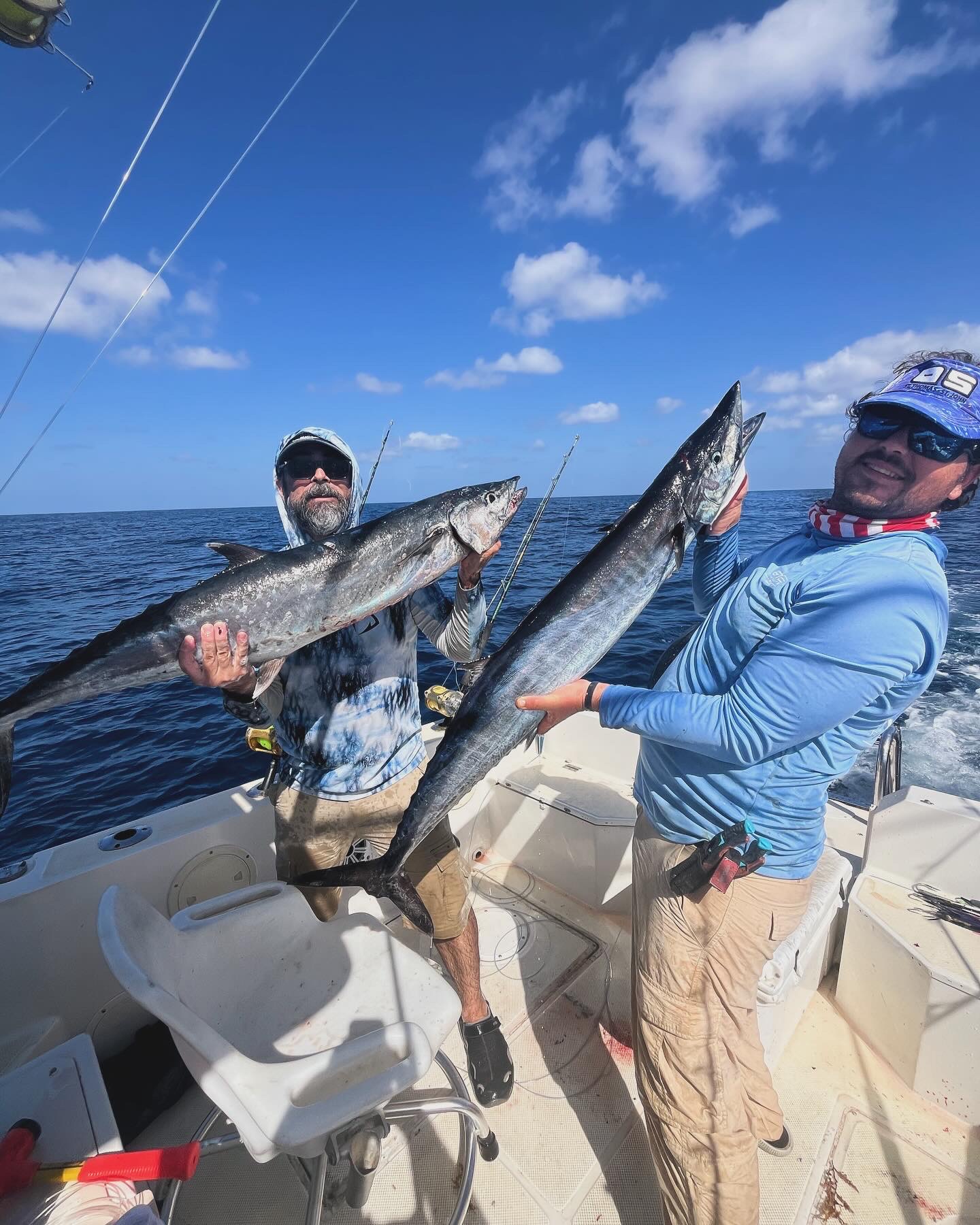 Double wahoo held up in the cockpit offshore