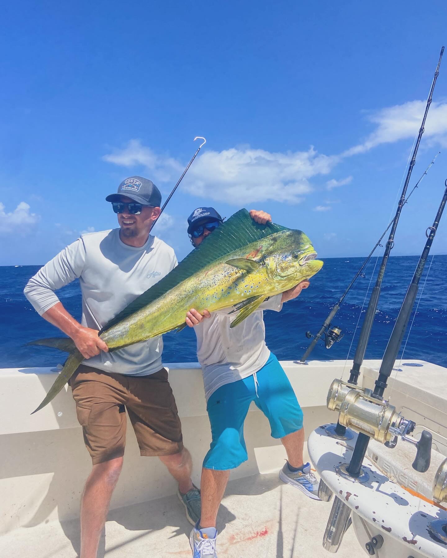 Anglers holding a big bull mahi on the deck