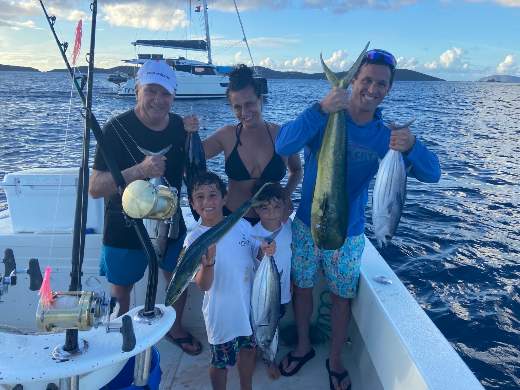 Family on the boat at sunset with mahi and tuna