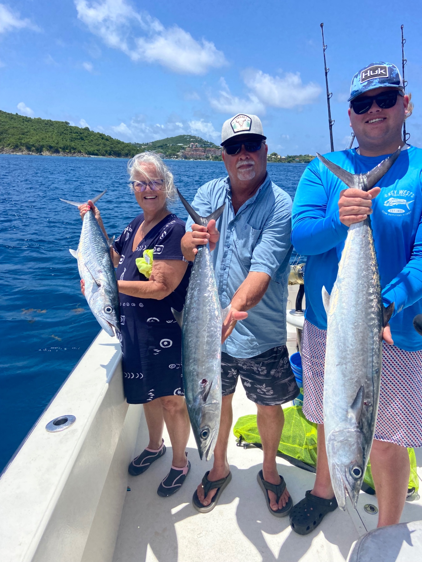 Three anglers holding kingfish offshore of St. Thomas